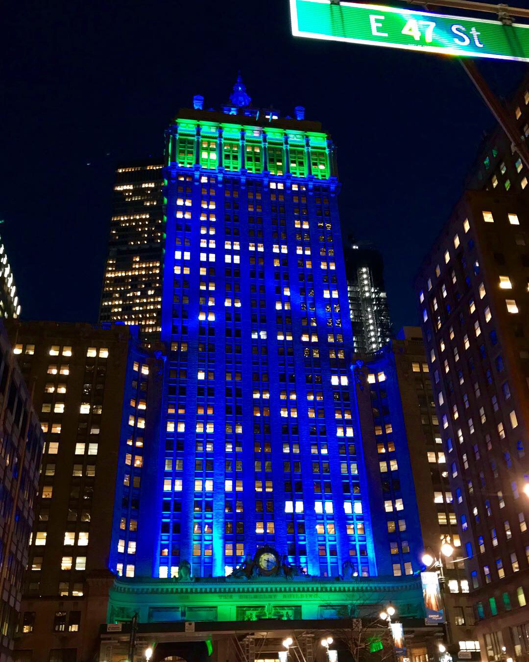 The Helmsley Building, lit in green and blue, photographed from the ground.